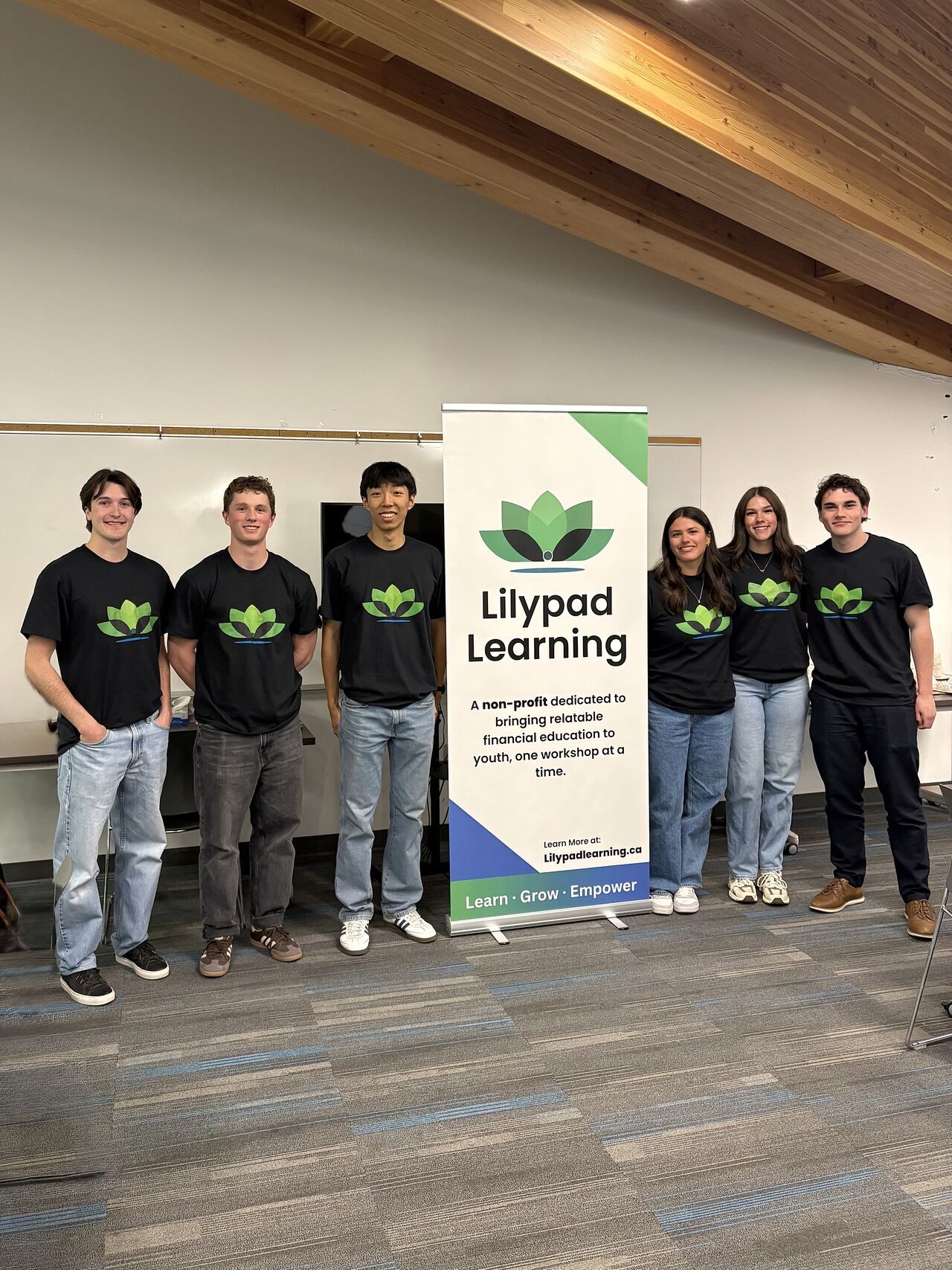 Six Lilypad Learning team members standing with the Lilypad banner